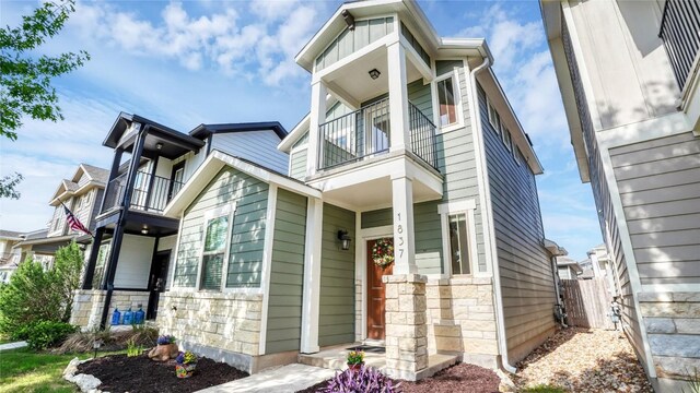 1837 Artesian Springs Xing, Leander, TX 78641 - view of front of home with fence, stone siding, and a balcony