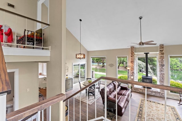 9 Stoney Creek Cv, Lakeway, TX 78734 - living room with a wood stove, high vaulted ceiling, wood finished floors, a ceiling fan, and a chandelier