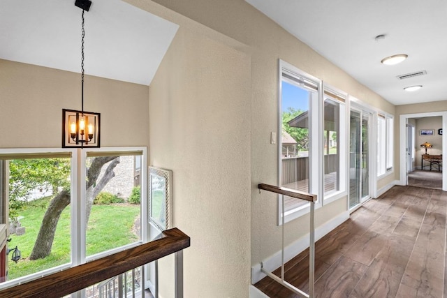 9 Stoney Creek Cv, Lakeway, TX 78734 - corridor featuring a chandelier, plenty of natural light, a textured wall, and wood finished floors