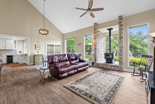 9 Stoney Creek Cv, Lakeway, TX 78734 - living area with beverage cooler, a wood stove, wood finished floors, high vaulted ceiling, and ceiling fan
