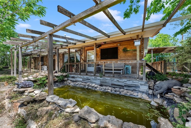 exterior space featuring a small pond and a pergola