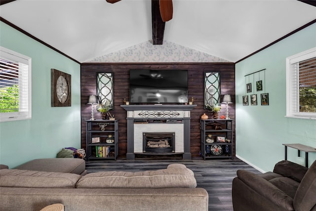living area featuring vaulted ceiling with beams, wood finished floors, ceiling fan, and a healthy amount of sunlight