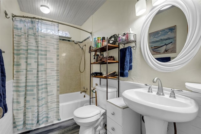 bathroom featuring shower / bath combo, a sink, and toilet