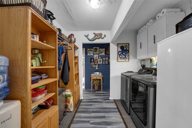 laundry room with separate washer and dryer, dark wood-style floors, a textured ceiling, and cabinet space