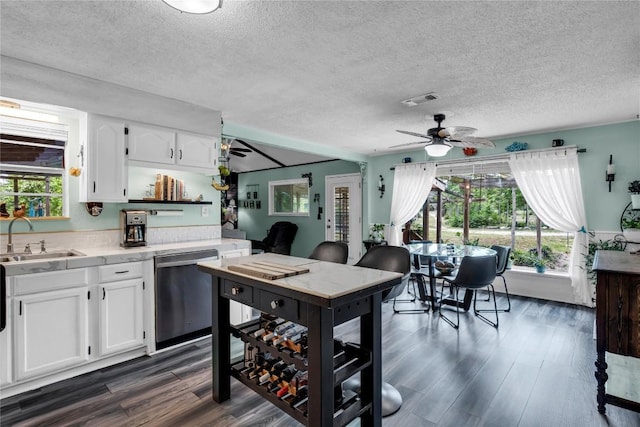 kitchen featuring a sink, dishwasher, ceiling fan, light countertops, and white cabinets