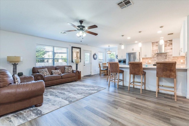 219 Quarry Ln, Liberty Hill, TX 78642 - living area featuring wood finished floors, visible vents, baseboards, and ceiling fan