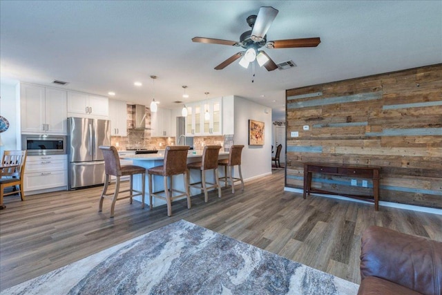 219 Quarry Ln, Liberty Hill, TX 78642 - dining area featuring wood walls, wood finished floors, visible vents, and ceiling fan