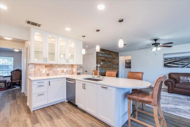 219 Quarry Ln, Liberty Hill, TX 78642 - kitchen featuring light countertops, visible vents, stainless steel dishwasher, a sink, and a peninsula