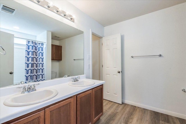 219 Quarry Ln, Liberty Hill, TX 78642 - bathroom featuring baseboards, wood finished floors, visible vents, and a sink