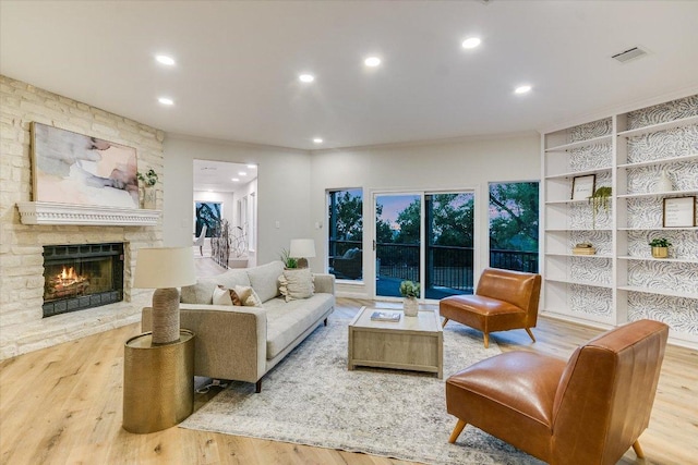 8105 Bell Mountain Dr, Austin, TX 78730 - living room featuring wood finished floors, a stone fireplace, and recessed lighting