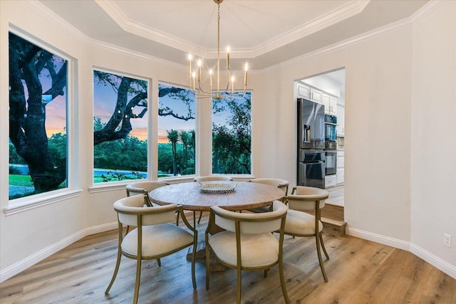 8105 Bell Mountain Dr, Austin, TX 78730 - dining space with light wood-style flooring, a chandelier, a raised ceiling, and crown molding