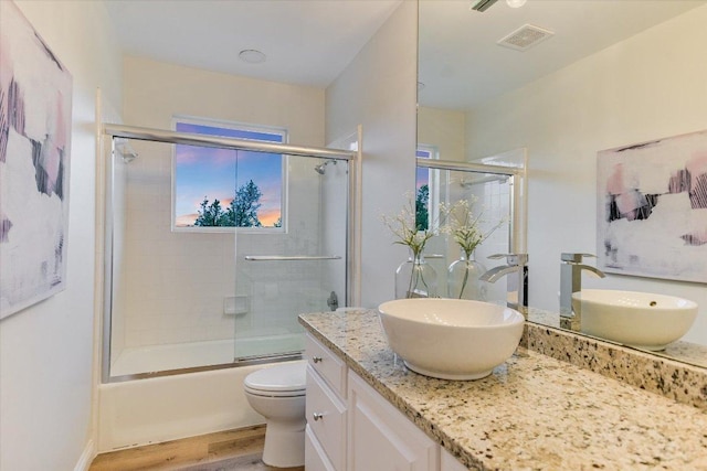 8105 Bell Mountain Dr, Austin, TX 78730 - bathroom with vanity, wood finished floors, and bath / shower combo with glass door