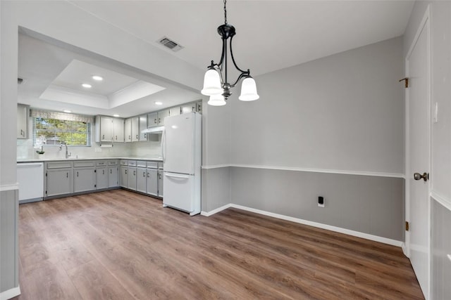 1609 Oak Forest Dr, Round Rock, TX 78681 - kitchen featuring white appliances, wood finished floors, a raised ceiling, gray cabinets, and recessed lighting