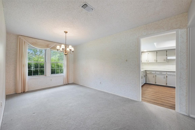 1609 Oak Forest Dr, Round Rock, TX 78681 - spare room featuring a chandelier, light colored carpet, a textured ceiling, wallpapered walls, and baseboards