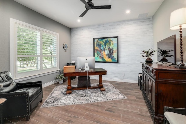 office featuring baseboards, an accent wall, recessed lighting, a ceiling fan, and wood finished floors