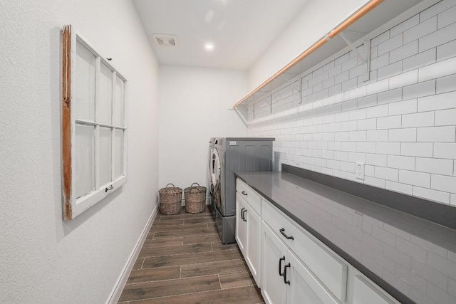 washroom featuring washing machine and clothes dryer, dark wood-style floors, baseboards, recessed lighting, and cabinet space
