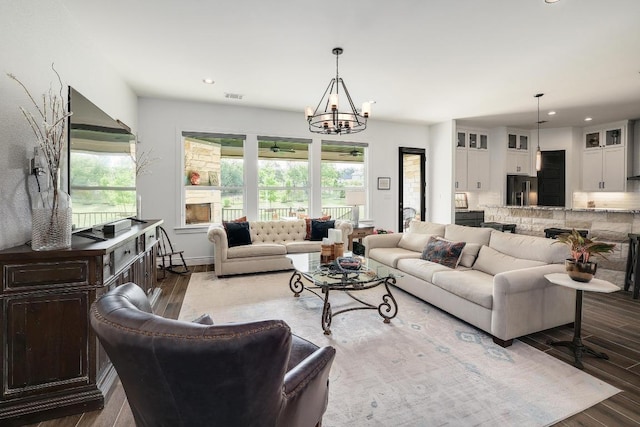 living area with wood finished floors, recessed lighting, a chandelier, and a healthy amount of sunlight