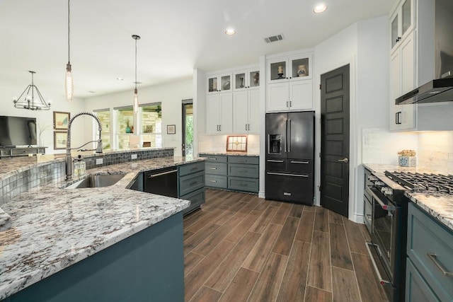 kitchen with recessed lighting, high end appliances, backsplash, a sink, and dark wood-type flooring
