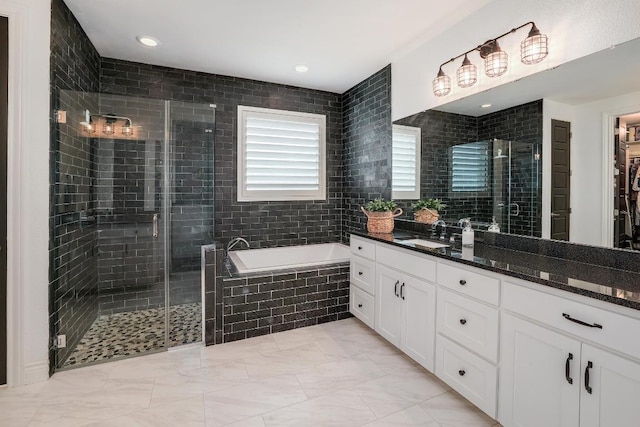 bathroom with a garden tub, vanity, marble finish floor, and a stall shower