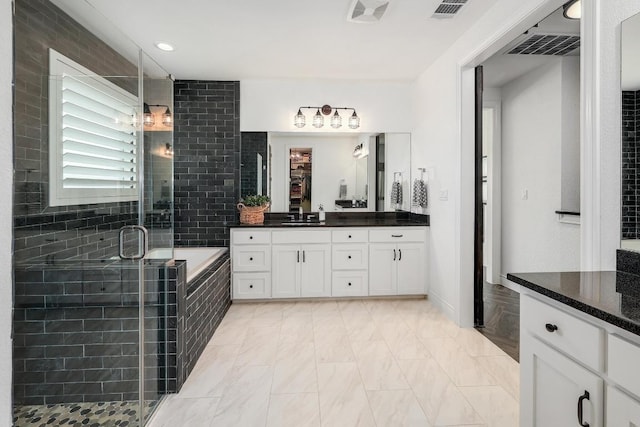 full bathroom featuring vanity, a garden tub, visible vents, and a shower stall