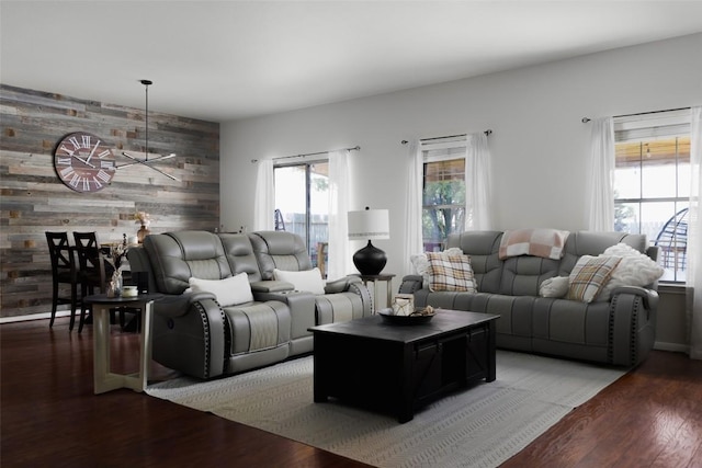 living room with wood walls, an accent wall, and wood finished floors
