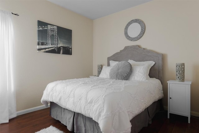 bedroom featuring wood-type flooring and baseboards