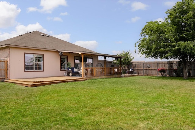 back of house featuring a fenced backyard, a wooden deck, and a lawn