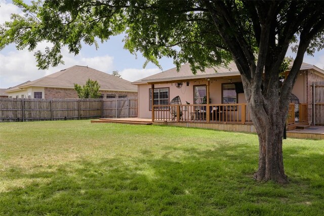 view of yard with a wooden deck and a fenced backyard