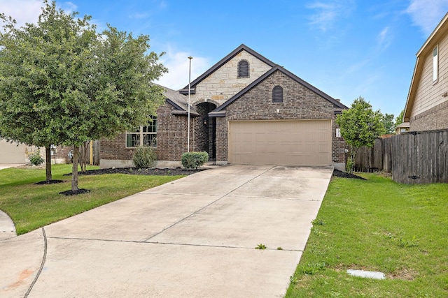 french country home with brick siding, an attached garage, driveway, and a front yard