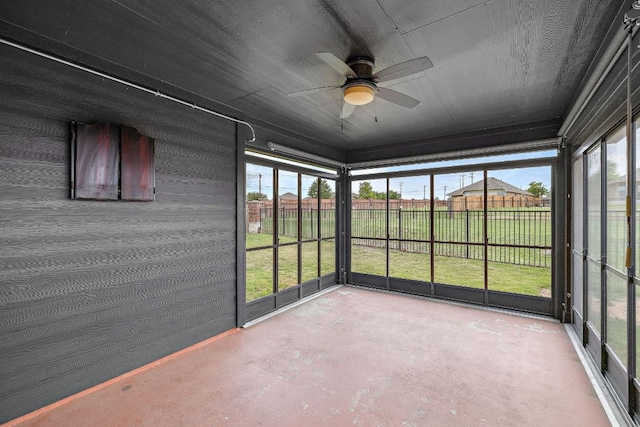 unfurnished sunroom featuring ceiling fan and plenty of natural light