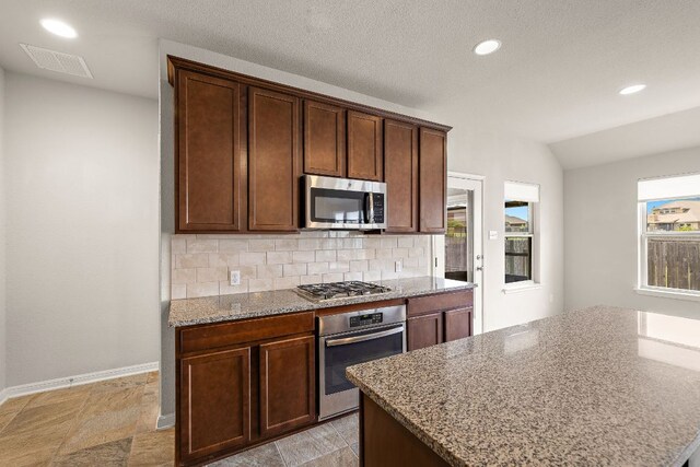 kitchen with light stone counters, stainless steel appliances, backsplash, visible vents, and recessed lighting