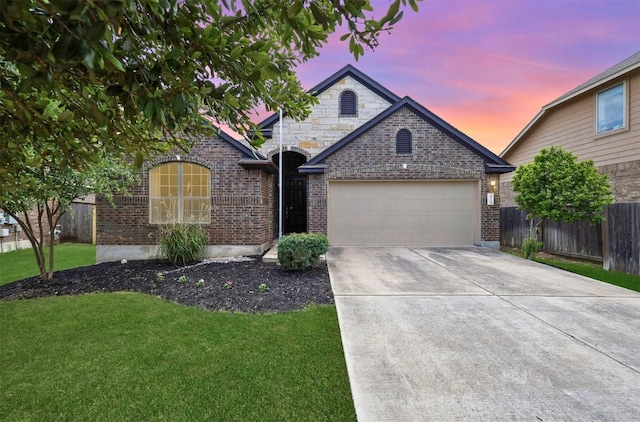 view of front facade with fence, concrete driveway, brick siding, a front yard, and a garage