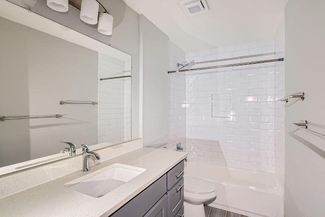 bathroom with tub / shower combination, toilet, vanity, and visible vents