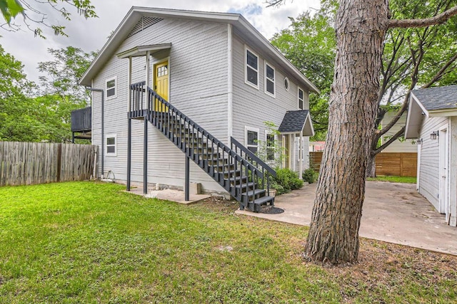 back of house featuring a lawn, a patio, and a fenced backyard