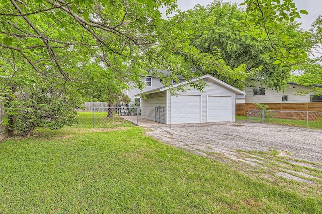 view of yard with a garage, an outbuilding, and fence