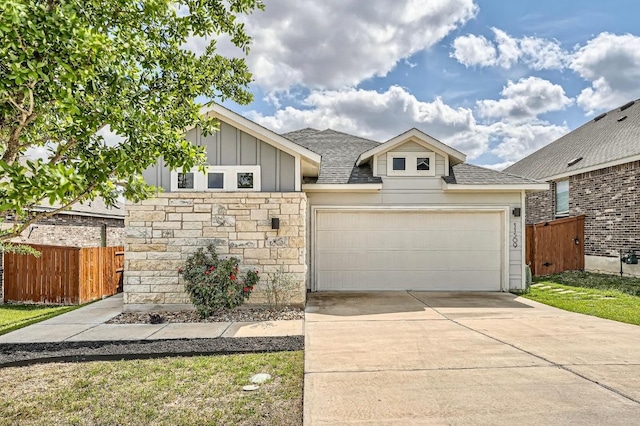 11509 Brindle Ct, Manor, TX 78653 - view of front of property with board and batten siding, concrete driveway, roof with shingles, an attached garage, and stone siding