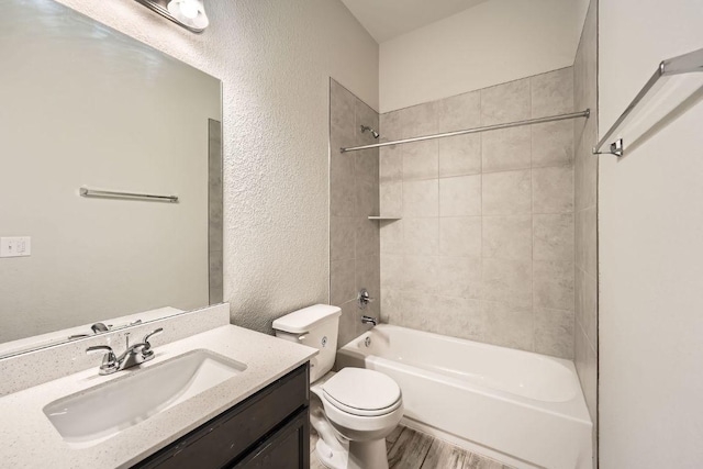 11509 Brindle Ct, Manor, TX 78653 - bathroom featuring a textured wall, toilet, vanity,  shower combination, and wood finished floors