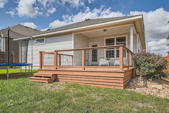 11509 Brindle Ct, Manor, TX 78653 - back of house with a trampoline, a lawn, and a wooden deck