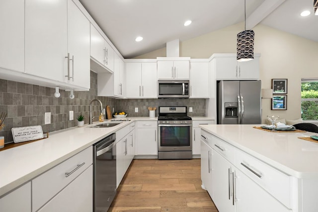 4709 Bandera Rd, Austin, TX 78721 - kitchen with stainless steel appliances, light wood-style floors, beamed ceiling, light countertops, and white cabinets