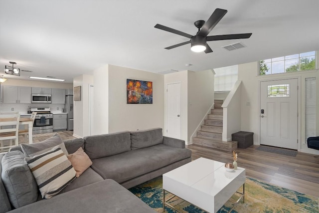 17320 Manish Dr, Pflugerville, TX 78660 - living area featuring stairway, wood finished floors, ceiling fan, and baseboards