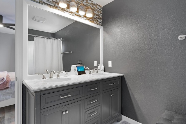 17320 Manish Dr, Pflugerville, TX 78660 - bathroom with double vanity, a textured wall, and curtained shower