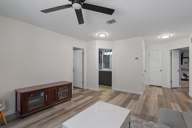 17320 Manish Dr, Pflugerville, TX 78660 - living room featuring a ceiling fan, light wood-style floors, and baseboards