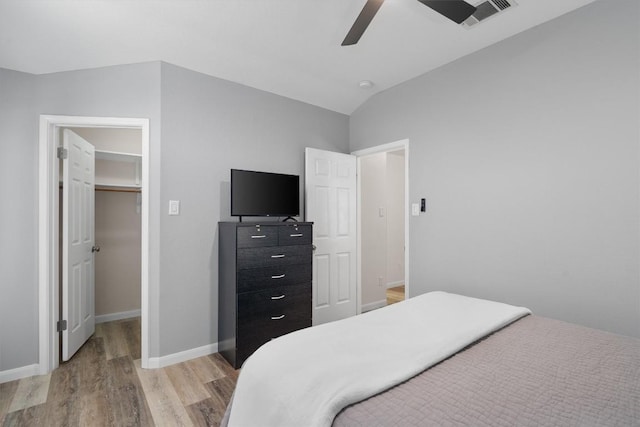 17320 Manish Dr, Pflugerville, TX 78660 - bedroom featuring light wood finished floors, baseboards, lofted ceiling, ceiling fan, and a spacious closet