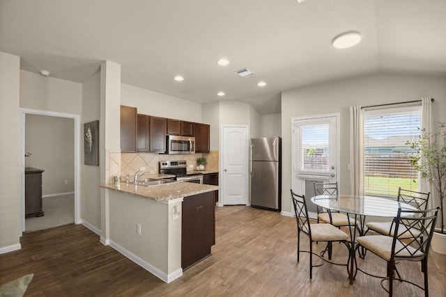 604 Nueces River Trl, Hutto, TX 78634 - kitchen featuring a sink, decorative backsplash, stainless steel appliances, dark wood finished floors, and visible vents