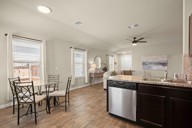 604 Nueces River Trl, Hutto, TX 78634 - kitchen with dishwasher, a sink, light wood-type flooring, a ceiling fan, and baseboards