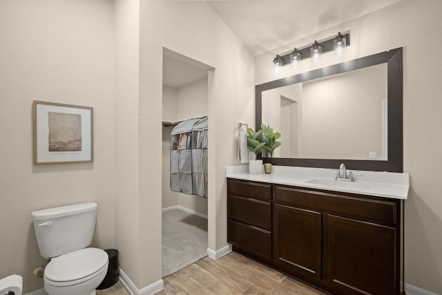 604 Nueces River Trl, Hutto, TX 78634 - bathroom featuring wood finished floors, vanity, toilet, and baseboards