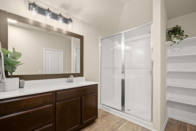 604 Nueces River Trl, Hutto, TX 78634 - bathroom featuring a spacious closet, vanity, wood finished floors, and a stall shower