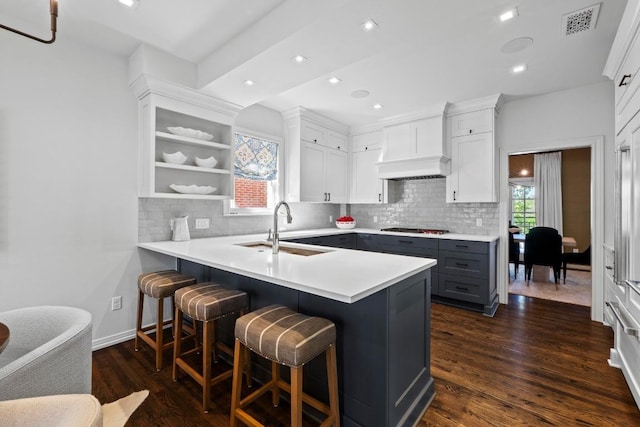2702 Hillview Green Ln, Austin, TX 78703 - kitchen featuring cooktop, gray cabinets, tasteful backsplash, dark wood-style flooring, and a breakfast bar
