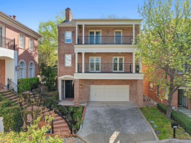 2702 Hillview Green Ln, Austin, TX 78703 - view of front of property with a balcony, french doors, brick siding, a garage, and decorative driveway