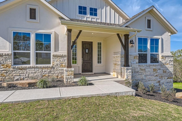 doorway to property with stucco siding, board and batten siding, a porch, a lawn, and stone siding